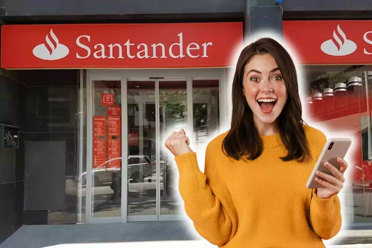 Una dona somrient amb un telèfon mòbil davant d'una sucursal del banc Santander.