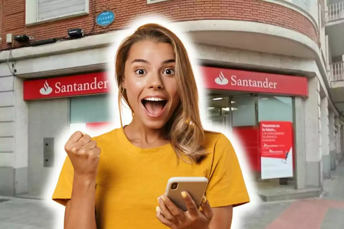 Una dona emocionada amb un telèfon mòbil davant d'una sucursal del banc Santander.