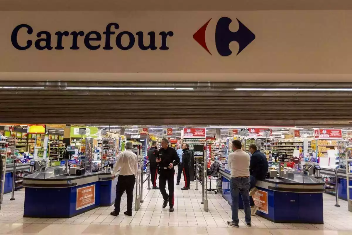 Clients en l'entrada d'una botiga de Carrefour