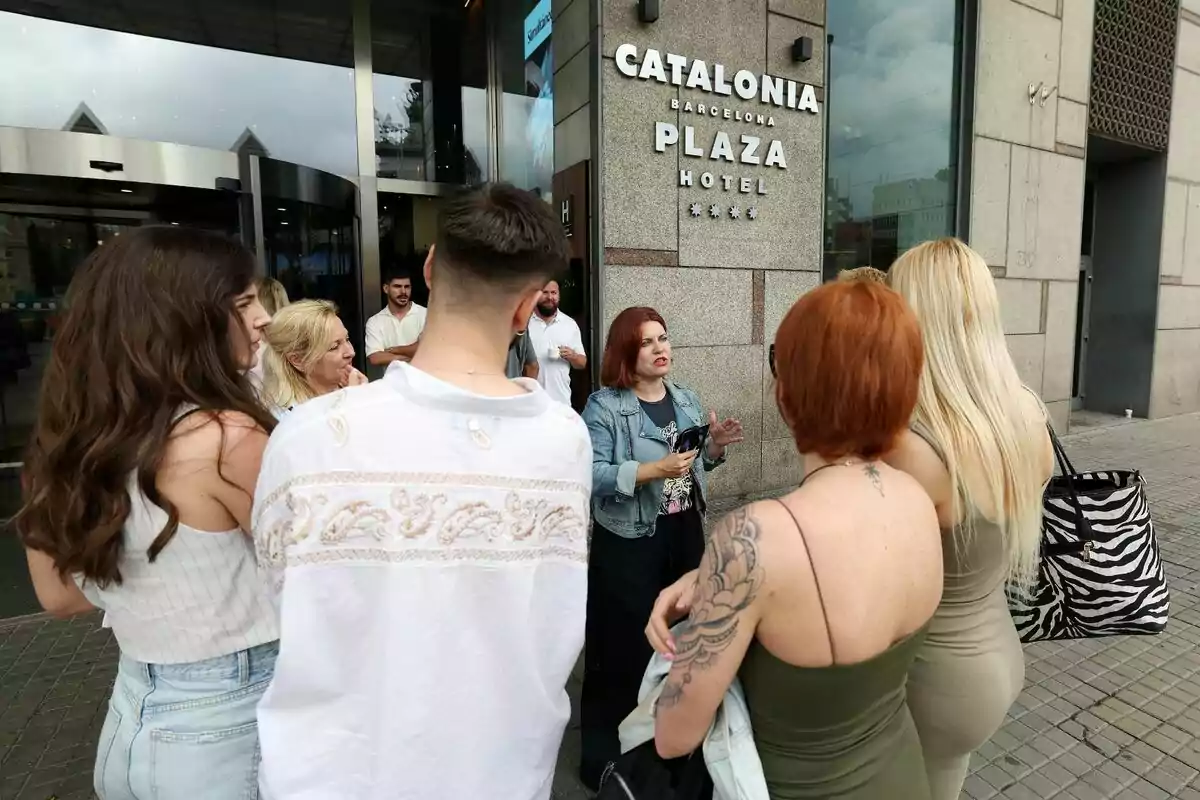 Un grup de persones estan reunits davant de l'entrada del Catalonia Barcelona Plaza Hotel, mentre una dona els parla amb Teresa Colomina, directora de càsting de Gran Hermano