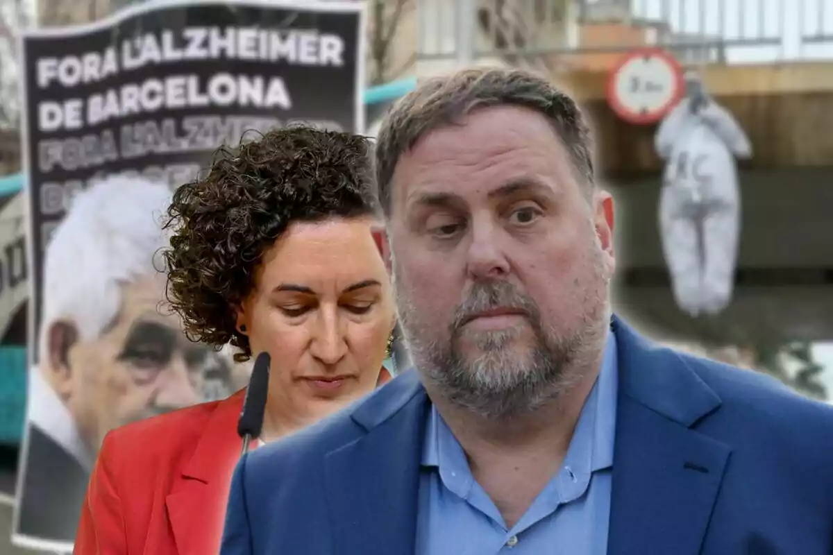 Dues persones en primer pla amb un cartell de fons que diu “Fora l'Alzheimer de Barcelona” i una figura penjada a la part posterior.