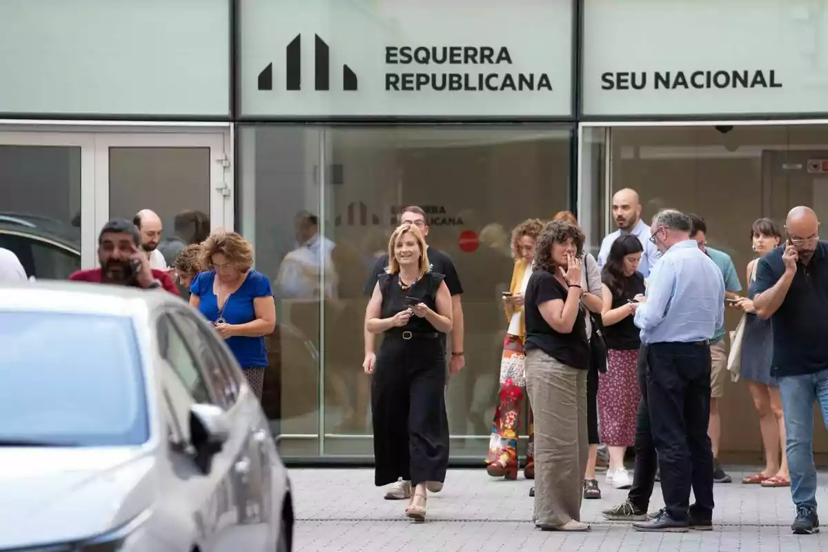 Diverses persones estan reunides davant d'un edifici amb el rètol "Esquerra Republicana Seu Nacional". En primer pla, Raquel Sans