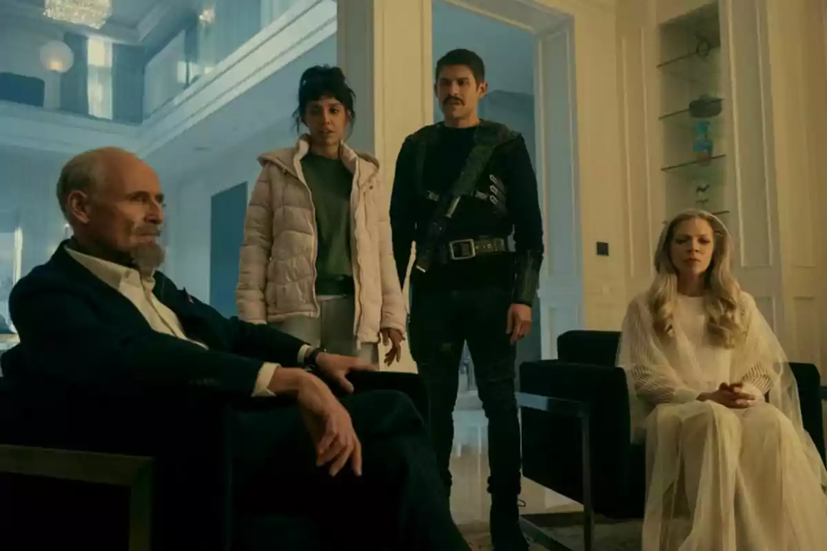 Cuatro personas están en una habitación elegante, dos sentadas y dos de pie, con una decoración moderna y luminosa en una escena de la última temporada de la serie The Umbrella Academy