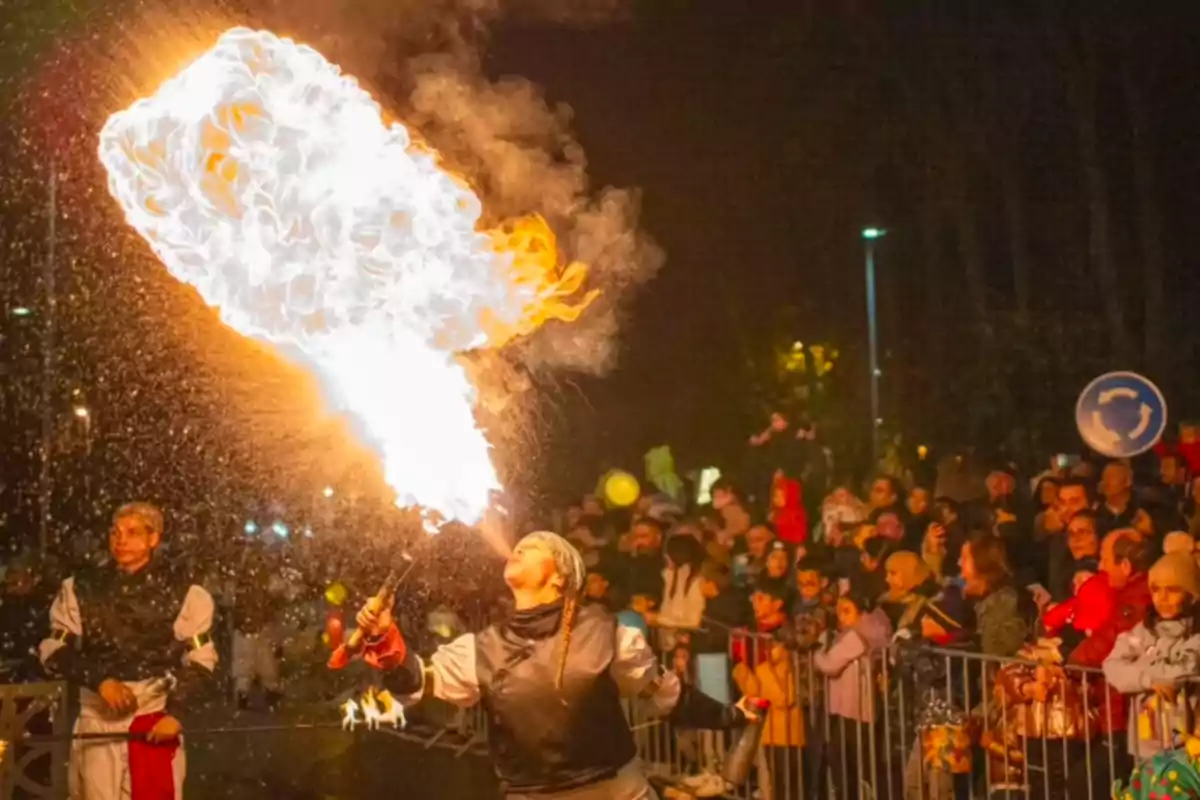 Una persona fa un espectacle de foc davant d'una multitud durant la nit. Una persona fa un espectacle de foc davant d'una multitud durant la nit.