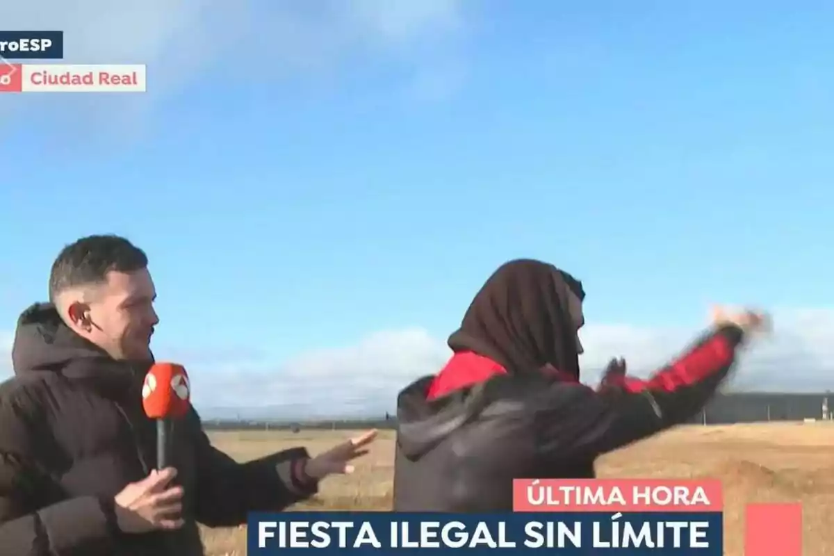 Un reportero con micrófono de Espejo Público entrevista a una persona en un campo abierto bajo un cielo despejado.