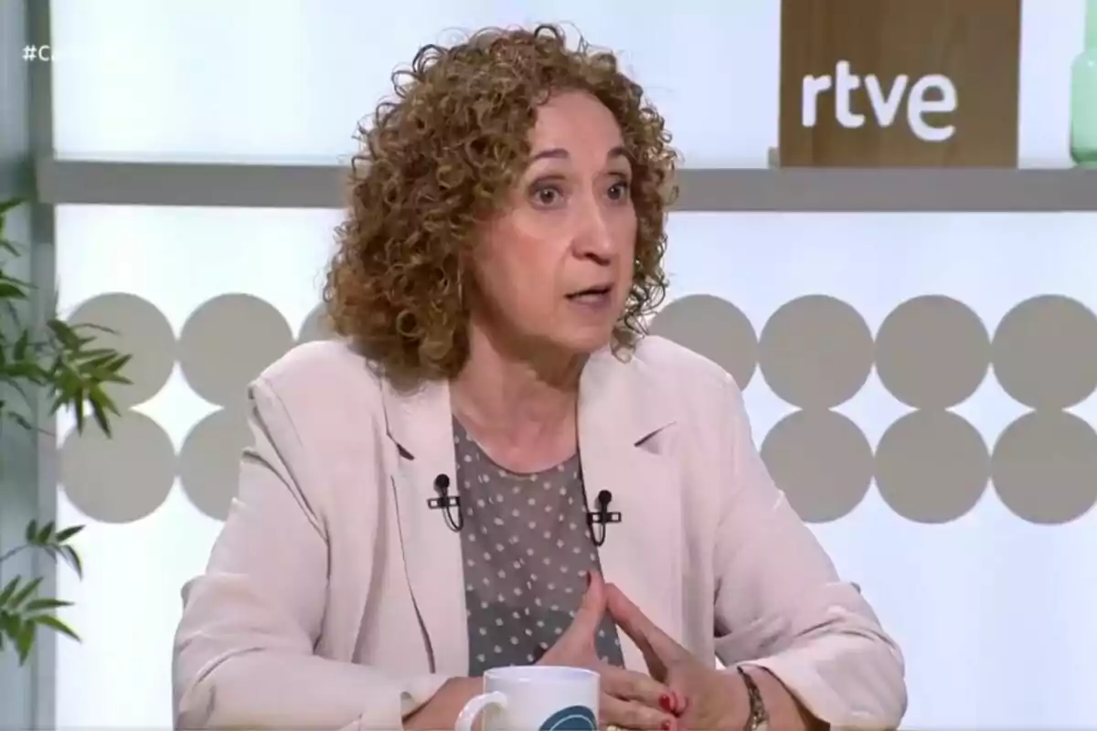 Dona de cabells arrissats i rossos parlant en un programa de televisió amb el logotip de rtve al fons