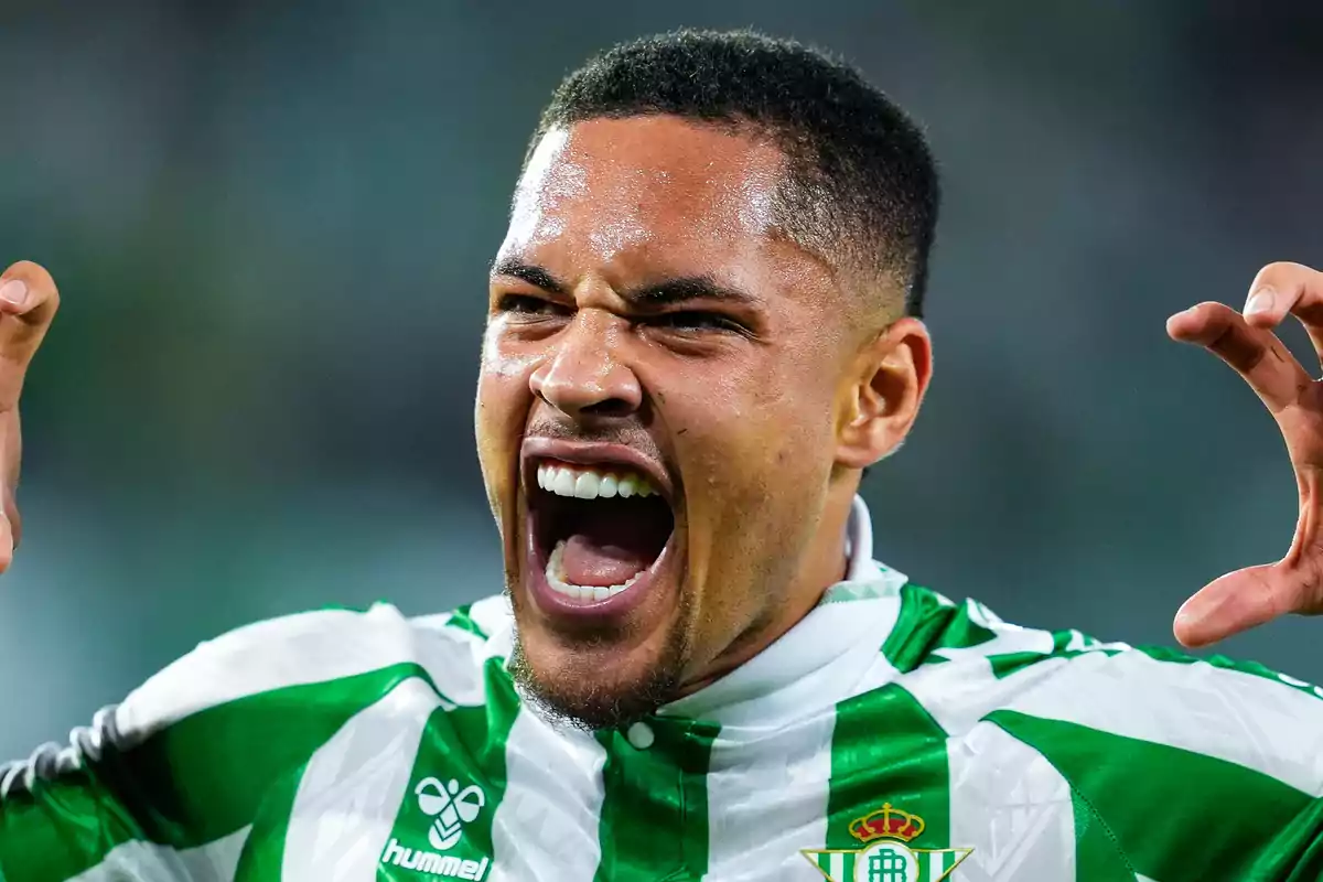 Jugador de futbol celebrant amb una expressió d'emoció i energia mentre vesteix l'uniforme del Real Betis.