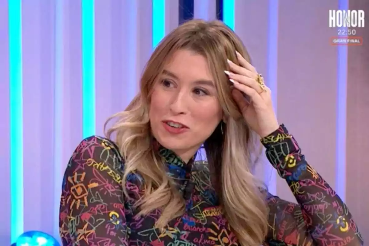 Eva Soriano con cabello rubio y ondulado está sentada en un estudio de televisión con luces azules de fondo y lleva una blusa con estampado colorido en 'Y ahora Sonsoles'.