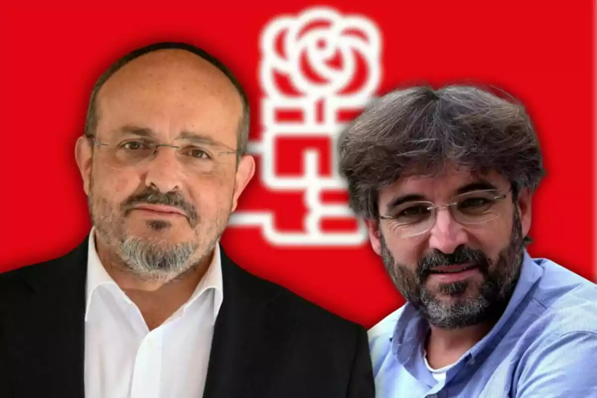Dos homes amb barba i ulleres posen davant d’un fons vermell amb el logotip d’una rosa blanca estilitzada