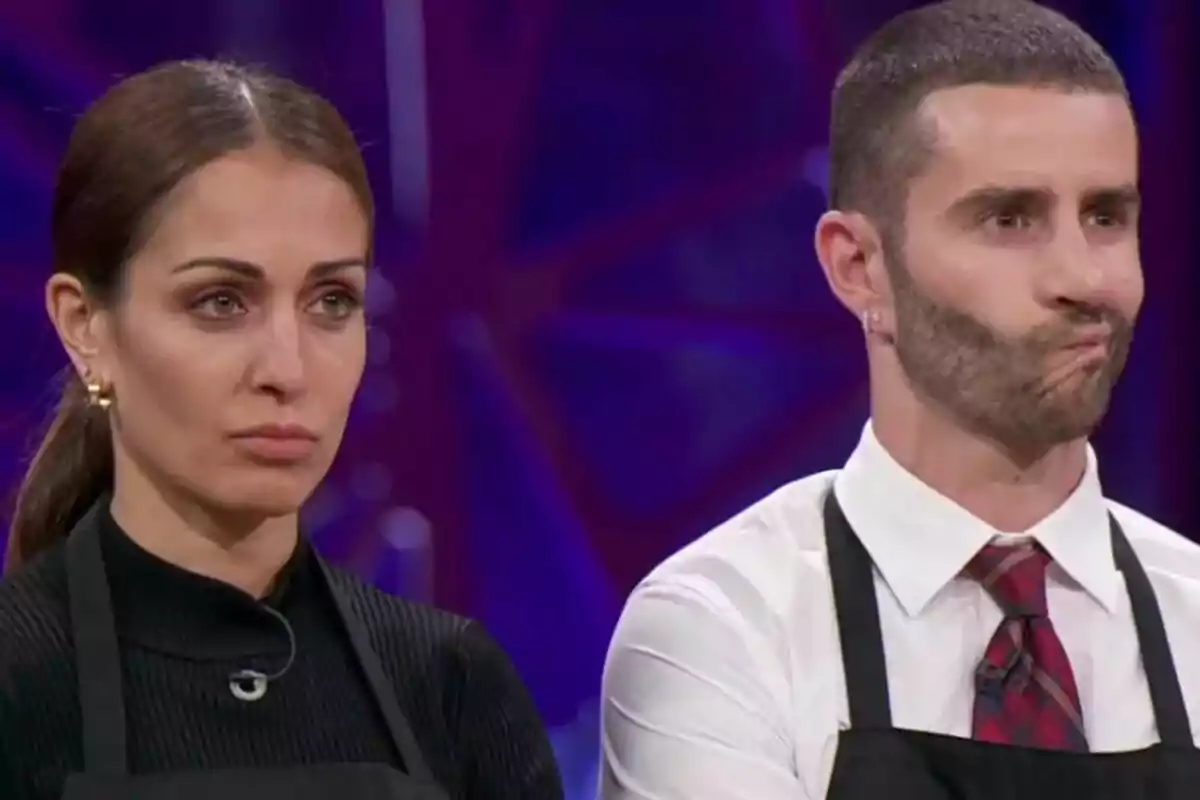 Hiba Abouk i Pelayo Díaz amb davantals negres a MasterChef Celebrity amb expressions serioses.