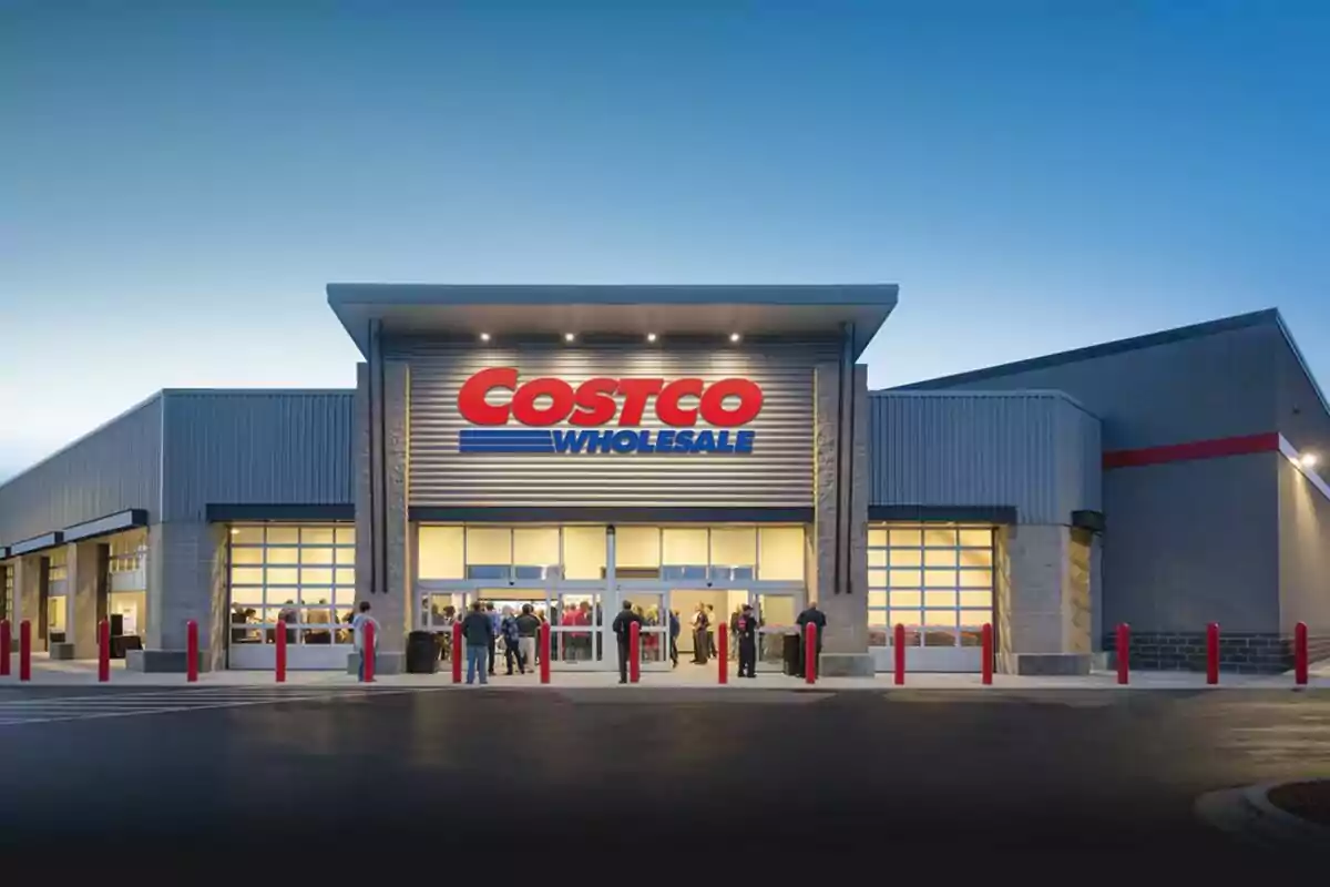 Fachada de una tienda Costco al atardecer con personas entrando y saliendo.