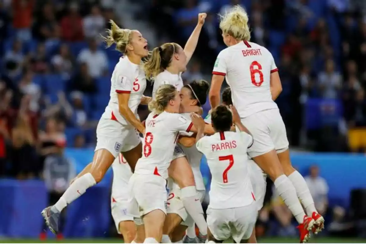 Jugadores de futbol celebrant un gol en equip durant un partit, vestint uniformes blancs amb detalls vermells. Jugadores de futbol celebrant un gol en equip durant un partit, vestint uniformes blancs amb detalls vermells.