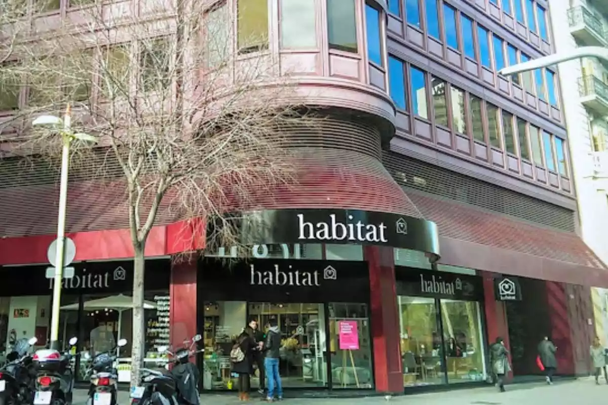 Façana de color vermell de la botiga de mobles Habitat a Barcelona amb tres persones a la porta