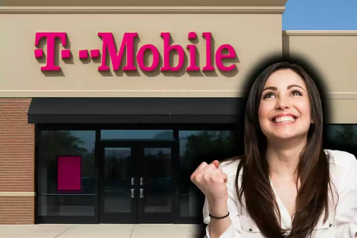 Una mujer sonriente con gesto de triunfo frente a una tienda de T-Mobile.