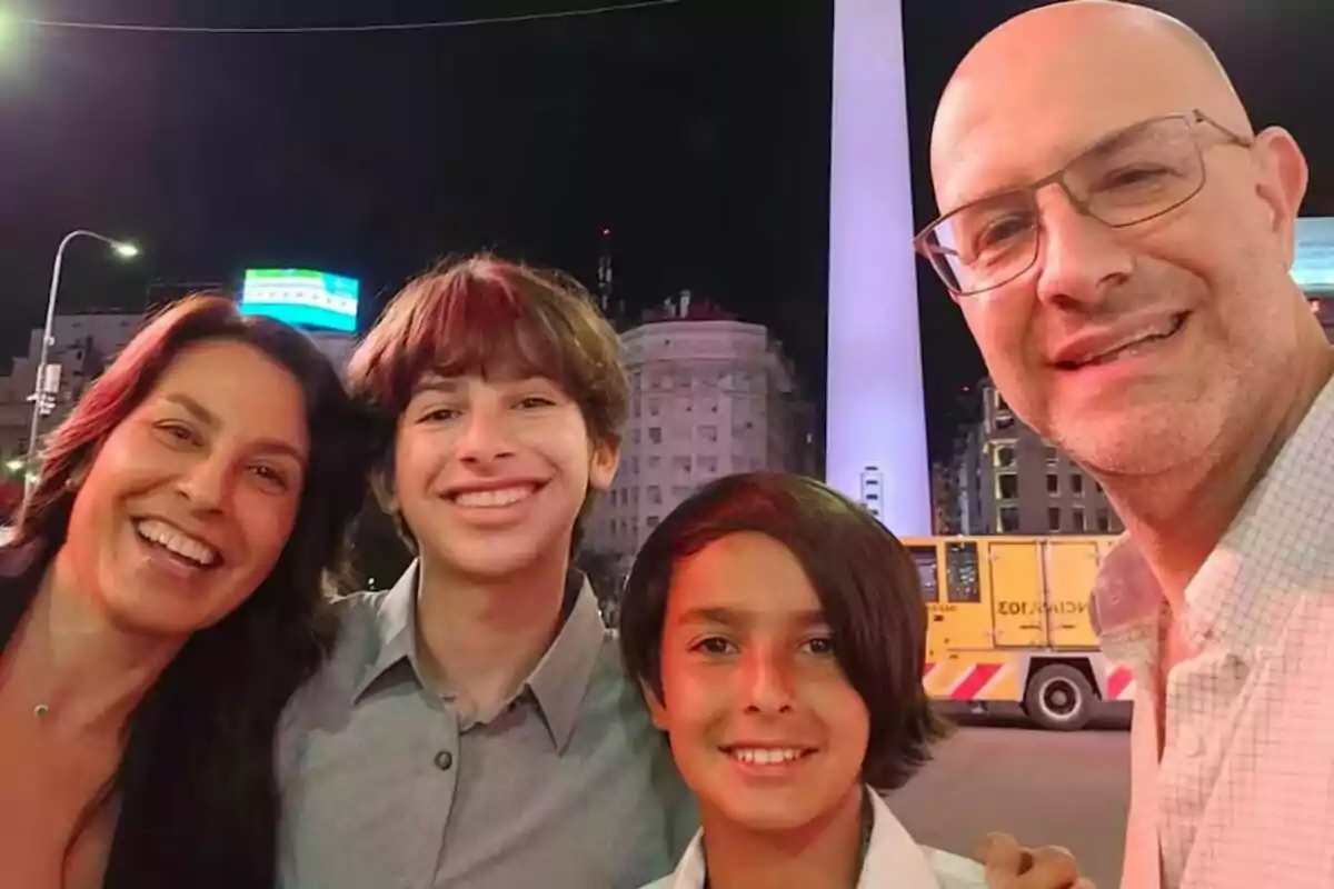 Una família somriu davant de l'Obelisc de Buenos Aires durant la nit.