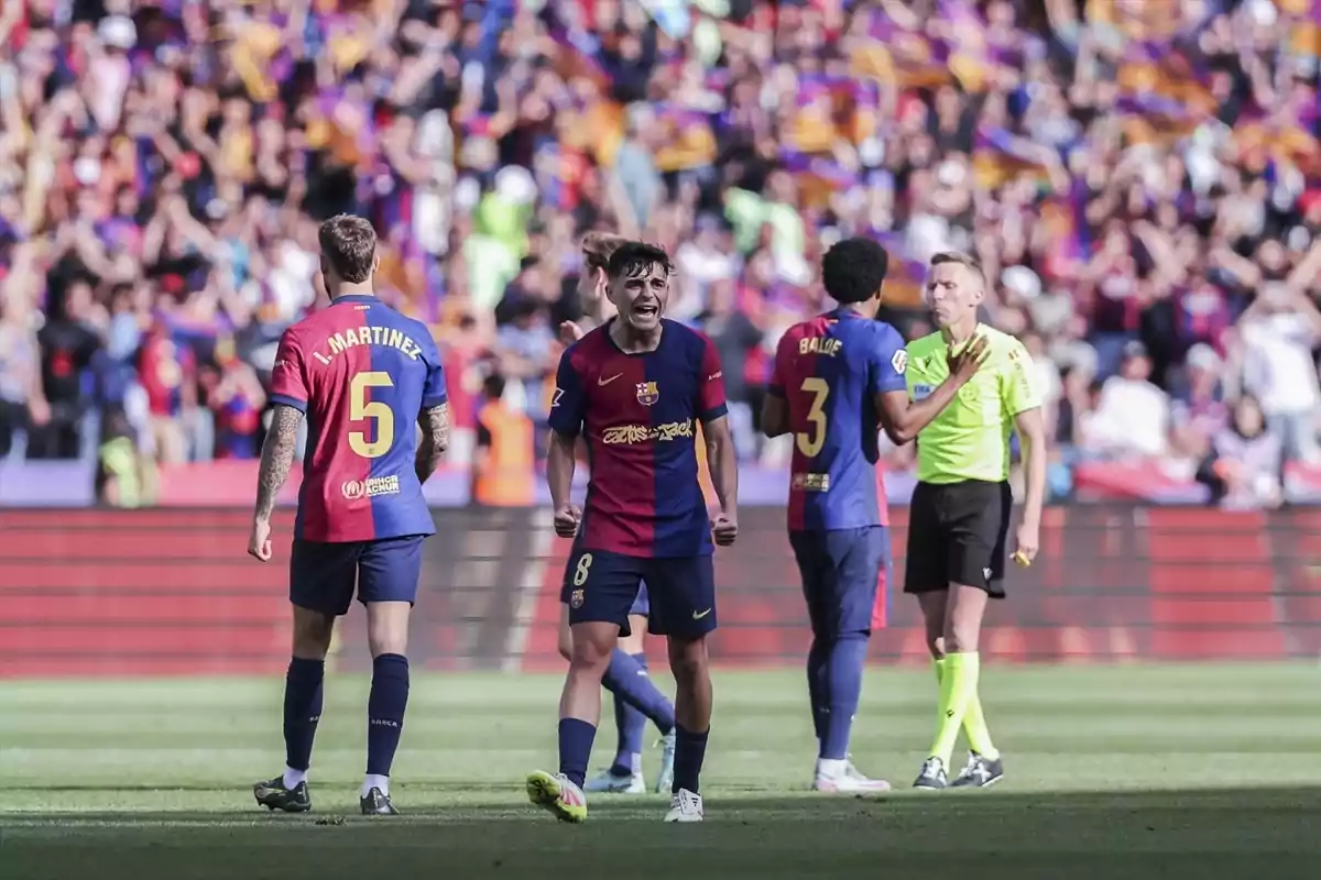 Jugadors de futbol al camp durant un partit amb un àrbitre i una multitud d'espectadors al fons. Jugadors de futbol al camp durant un partit amb un àrbitre i una multitud d'espectadors al fons.