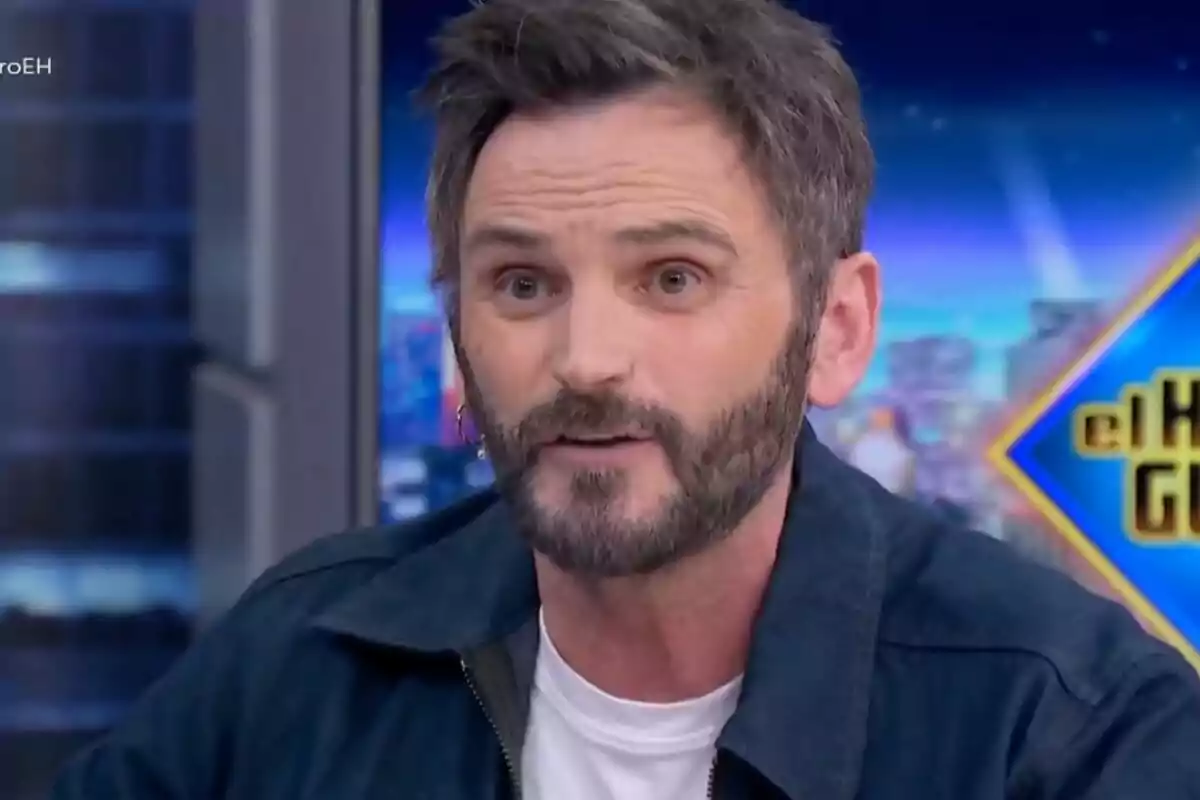 Fernando Tejero con barba y cabello oscuro en 'El Hormiguero' con un fondo colorido.