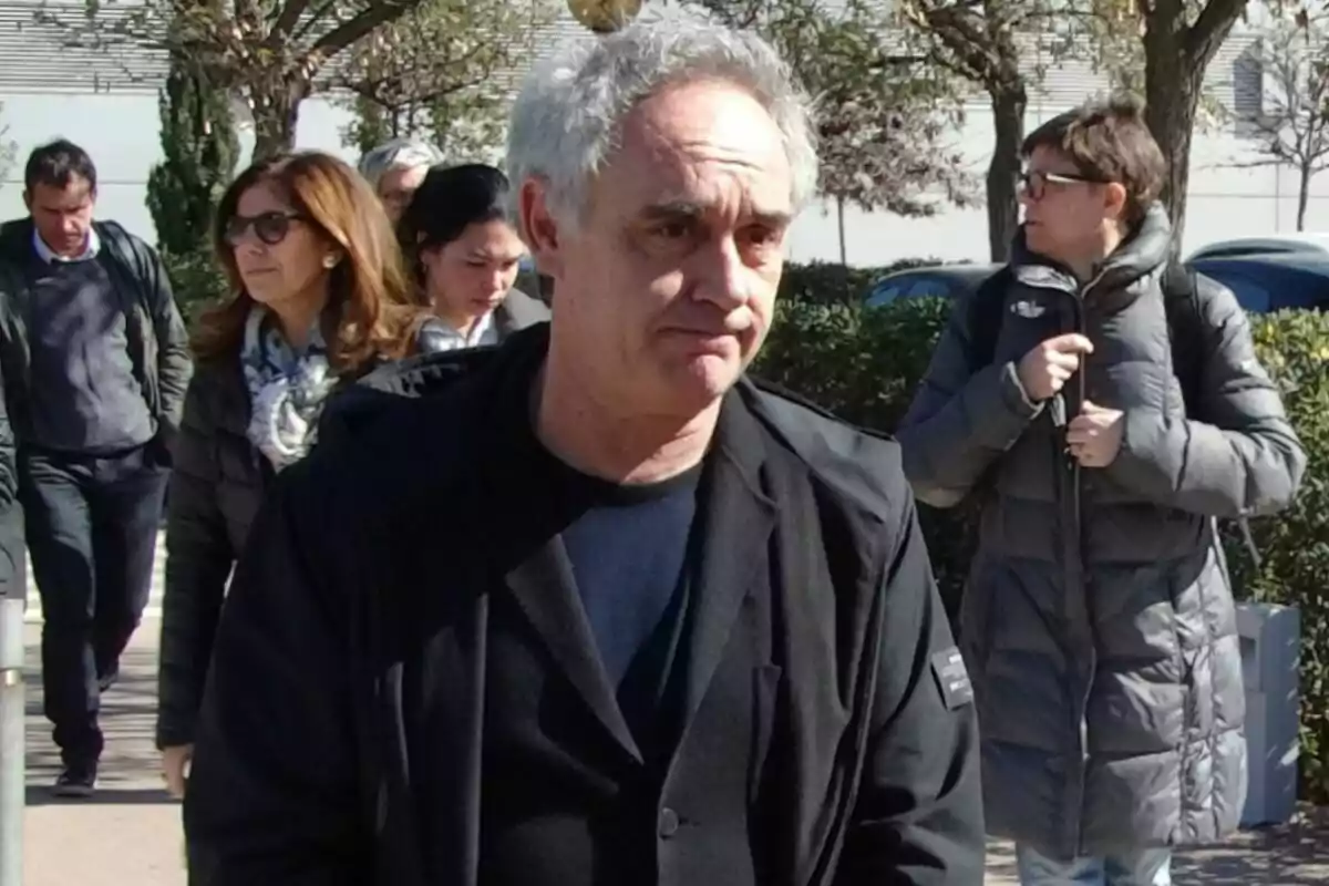 Un home caminant a la fresca envoltat de diverses persones en un dia assolellat. Un home caminant a la fresca envoltat de diverses persones en un dia assolellat.