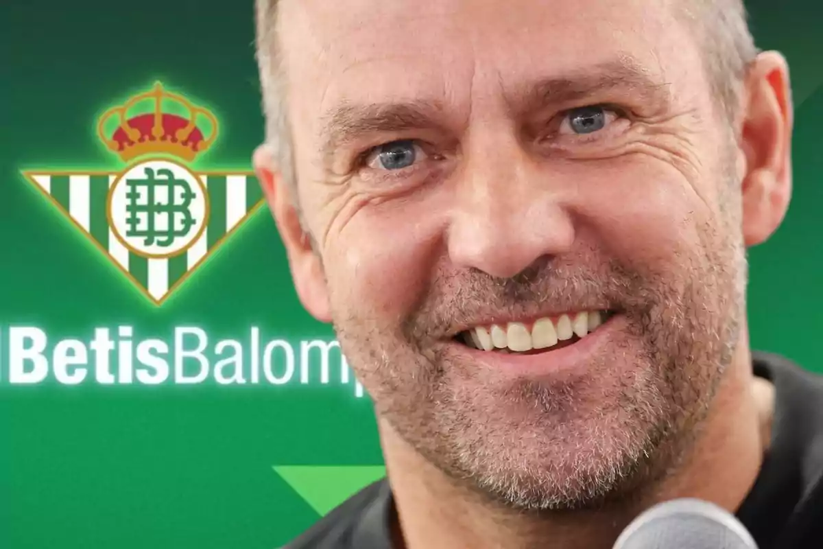 Un home somrient amb barba davant del logotip del Real Betis Balompié.