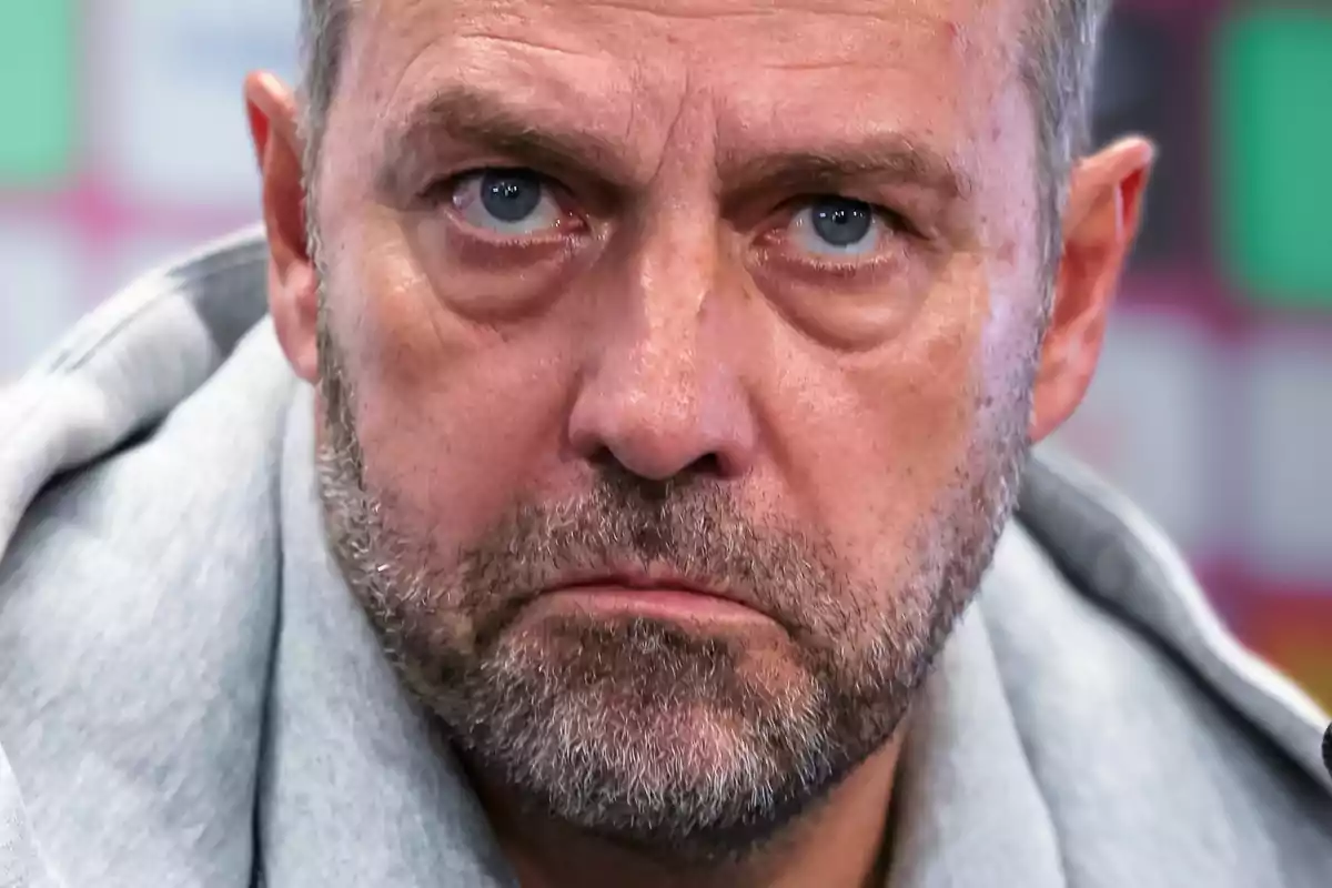 A man with a serious expression and a gray beard.