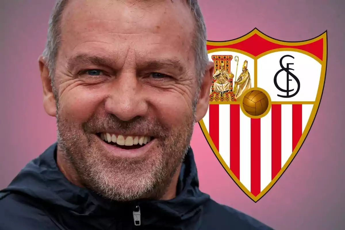 Un hombre sonriente con barba y cabello corto frente a un escudo del Sevilla FC.