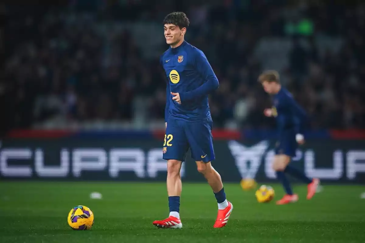 Un jugador de futbol amb uniforme blau i número 32 al camp durant un partit. Un jugador de futbol amb uniforme blau i número 32 al camp durant un partit.