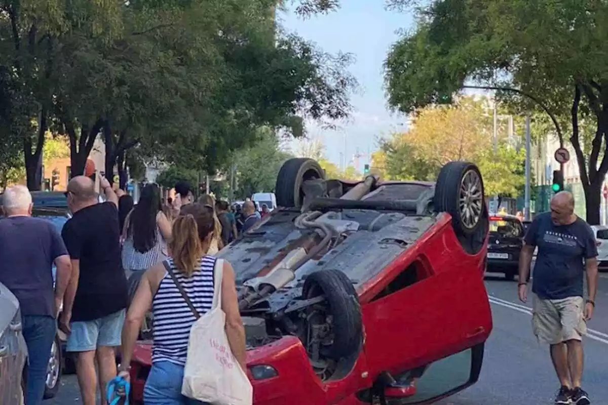 Foto d'un cotxe vermell accidentat a la carretera de Sevilla