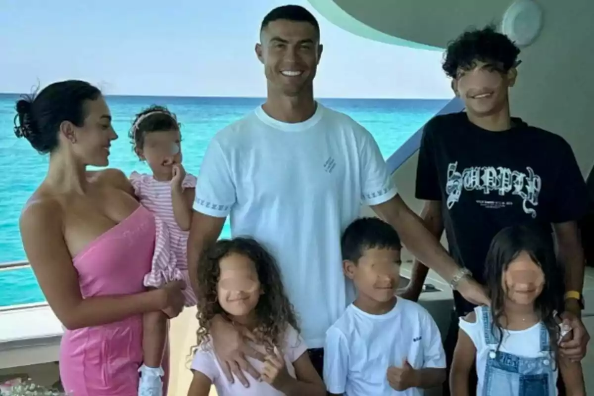 Familia -formada por Cristiano Ronaldo, Georgina Rodríguez y sus hijos- posando sonriente en un yate con el mar azul de fondo.
