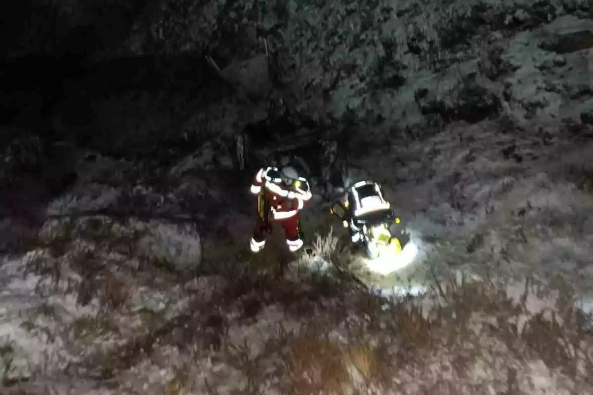 Un rescatador amb equip d'il·luminació treballa en un terreny nevat i fosc. Un rescatador amb equip d'il·luminació treballa en un terreny nevat i fosc.