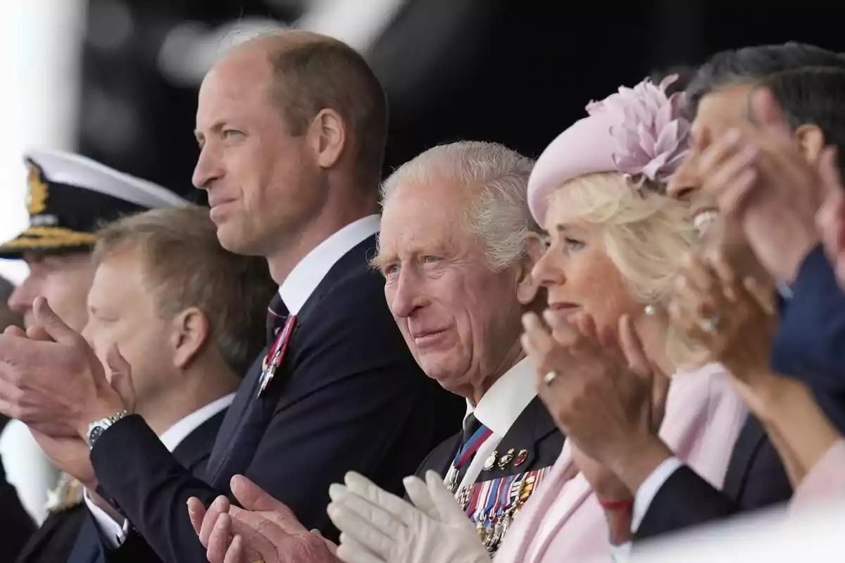 D-Day photo showing Prince William, King Charles III and Queen Camilla from the side, looking forward