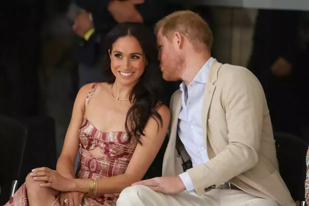 Photo of Prince Harry speaking into Meghan Markle's ear during the performance of the Danza Pies del Sol theatre group.