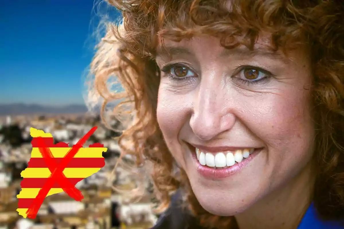 Dona somrient amb cabell arrissat i una bandera ratllada al fons.