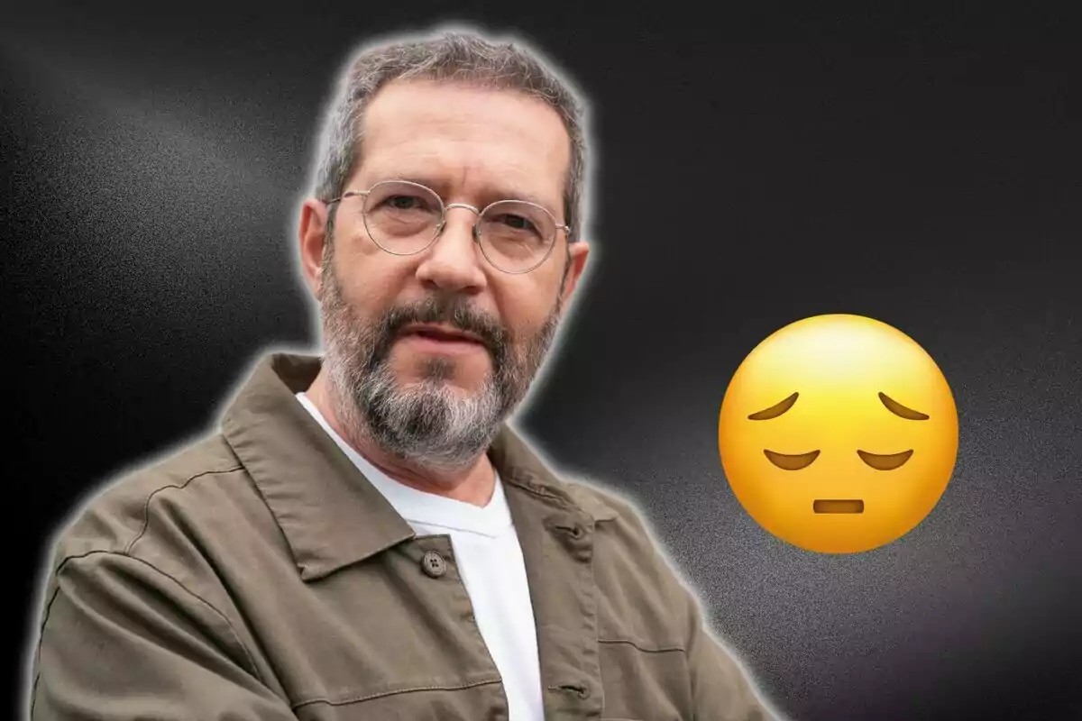 Home amb barba i ulleres al costat d'un emoji d'expressió trista sobre un fons fosc.