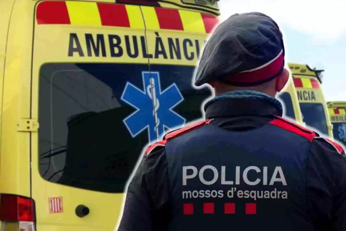 Un agent de la policia dels Mossos d'Esquadra d'esquena davant d'una ambulància groga amb la paraula "AMBULÀNCIA" escrita a la part del darrere.