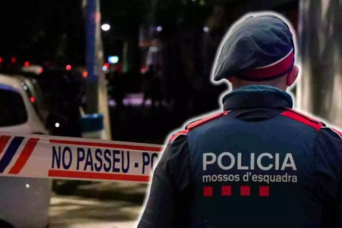 Un agent de policia dels Mossos d'Esquadra d'esquena davant d'una cinta de seguretat que diu "NO PASSEU - POLICIA".