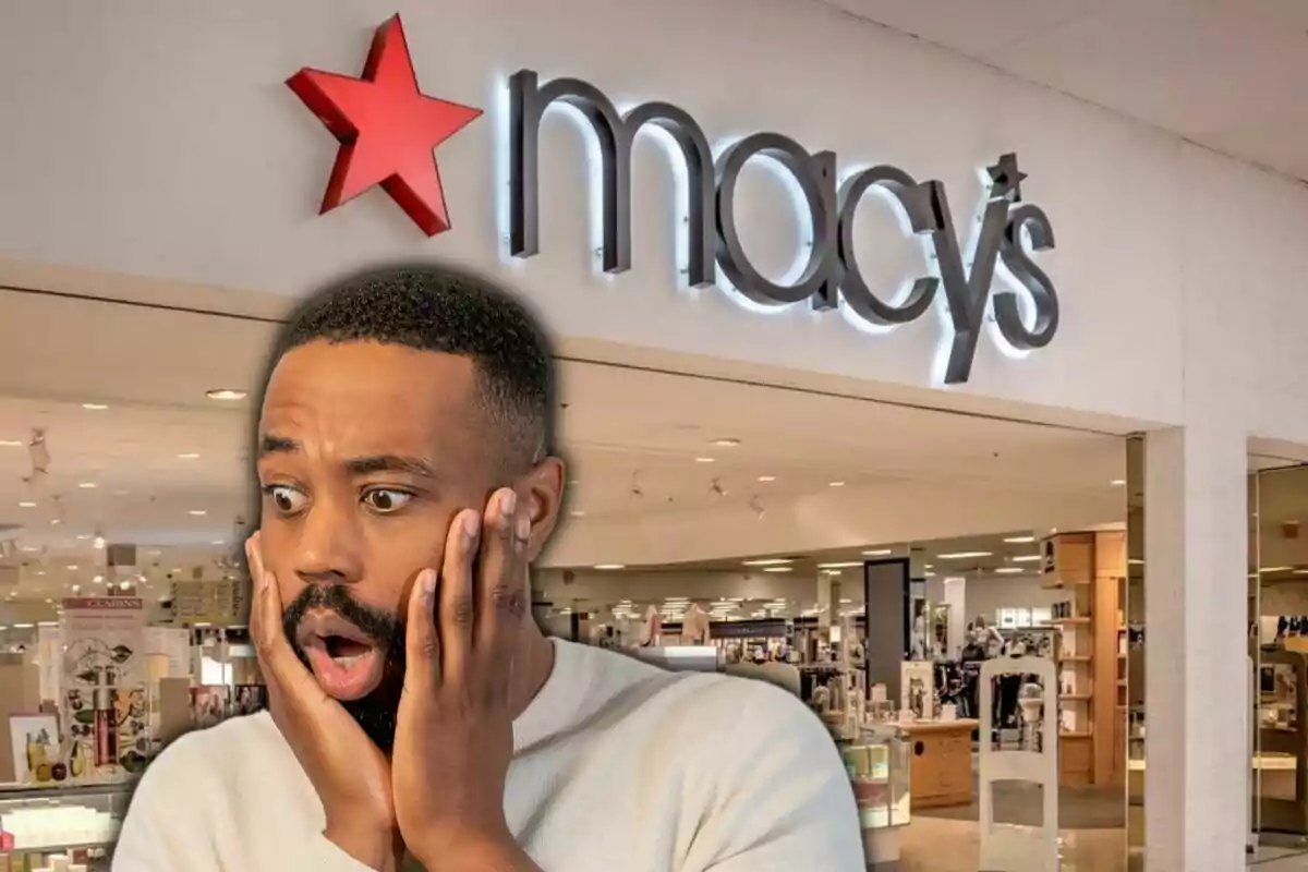 A man with a surprised expression in front of a Macy's store entrance.