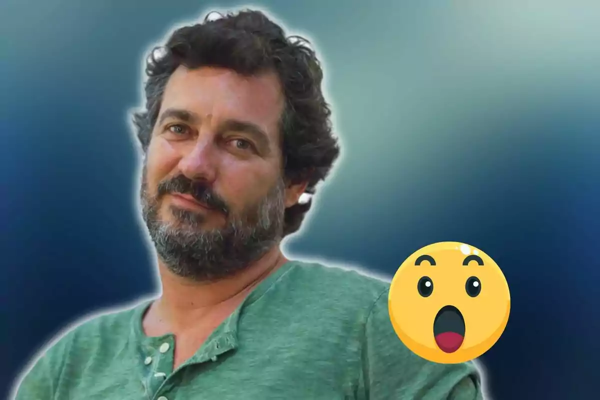 Home amb barba i cabell arrissat, vestit amb samarreta verda, acompanyat d'un emoji de cara sorpresa sobre un fons blau difuminat.