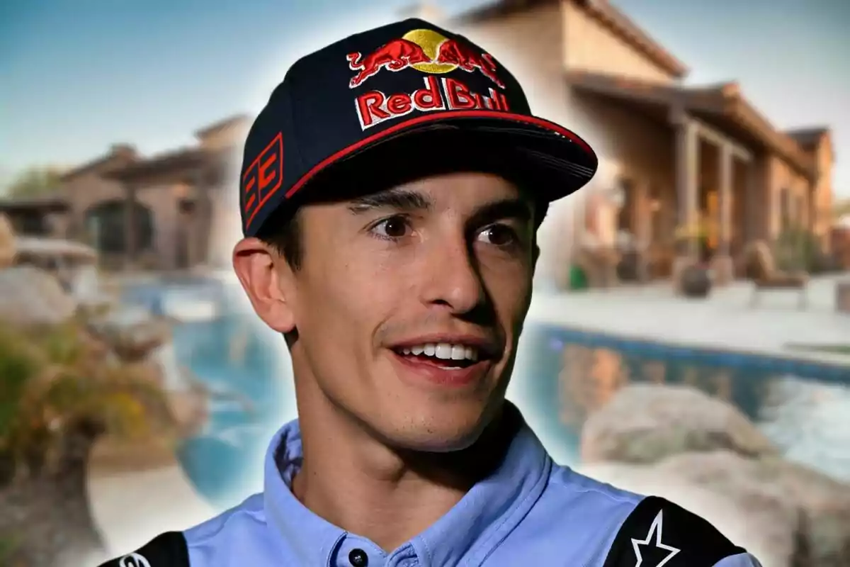 A man wearing a Red Bull cap smiles in front of a house with a pool.