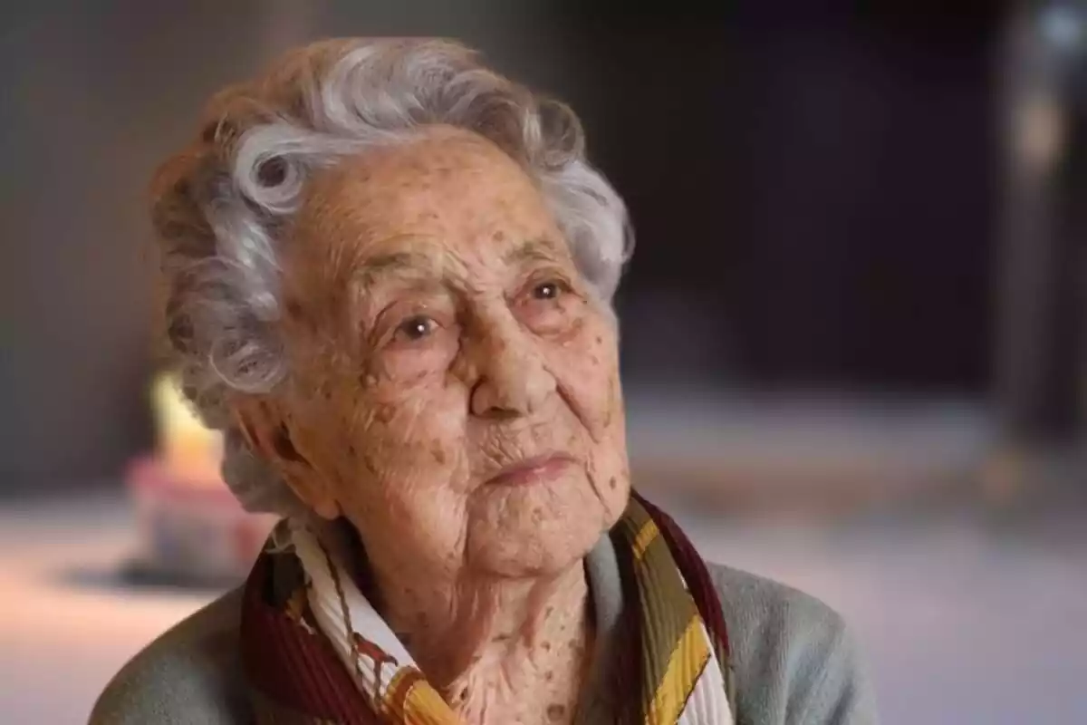 Fotomuntatge amb una imatge al capdavant de Maria Branyas, la dona més vella del món, i de fons una imatge difuminada d'aniversari