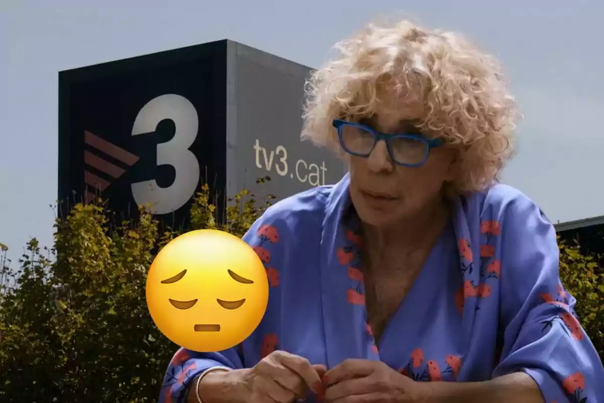 Una persona amb ulleres blaves i cabells arrissats està asseguda davant d'un edifici amb el logotip de TV3, amb un emoji de cara pensativa superposat.