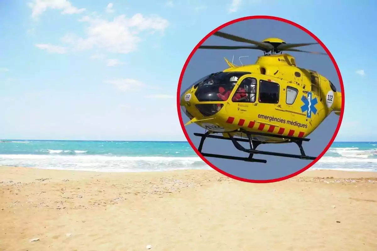 Helicòpter d'emergències mèdiques sobrevolant una platja amb el mar de fons.