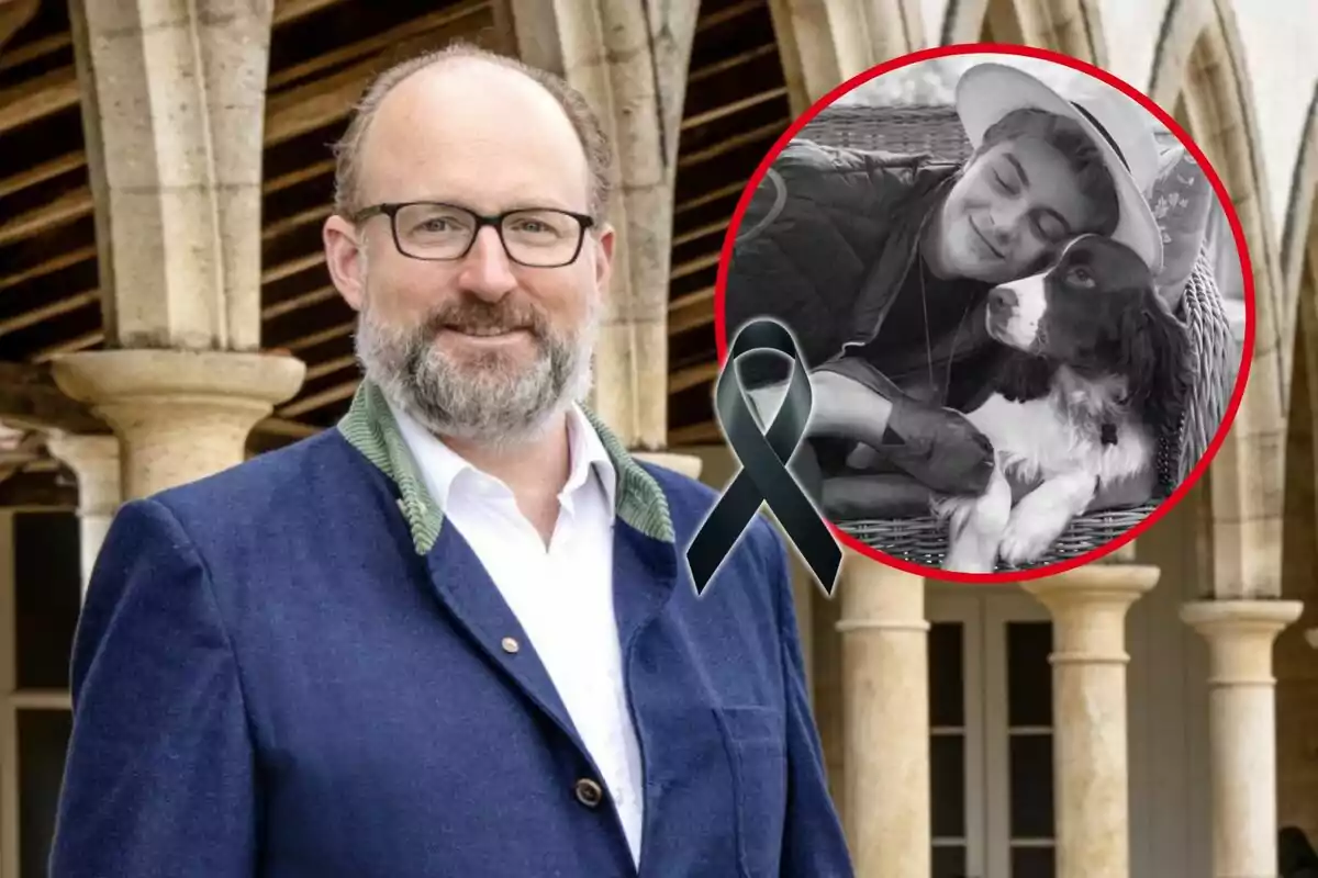 Un hombre con gafas y barba sonríe frente a un edificio con columnas; en la esquina superior derecha hay un círculo rojo con una imagen en blanco y negro de una persona abrazando a un perro, junto a un lazo negro.