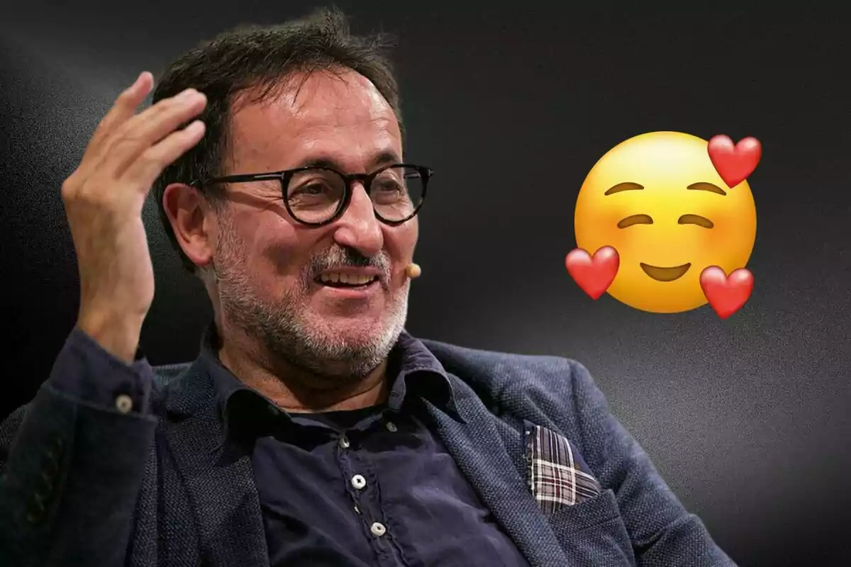 Un home amb ulleres i barba somriu mentre gesticula amb la mà, acompanyat d?un emoji somrient amb cors.