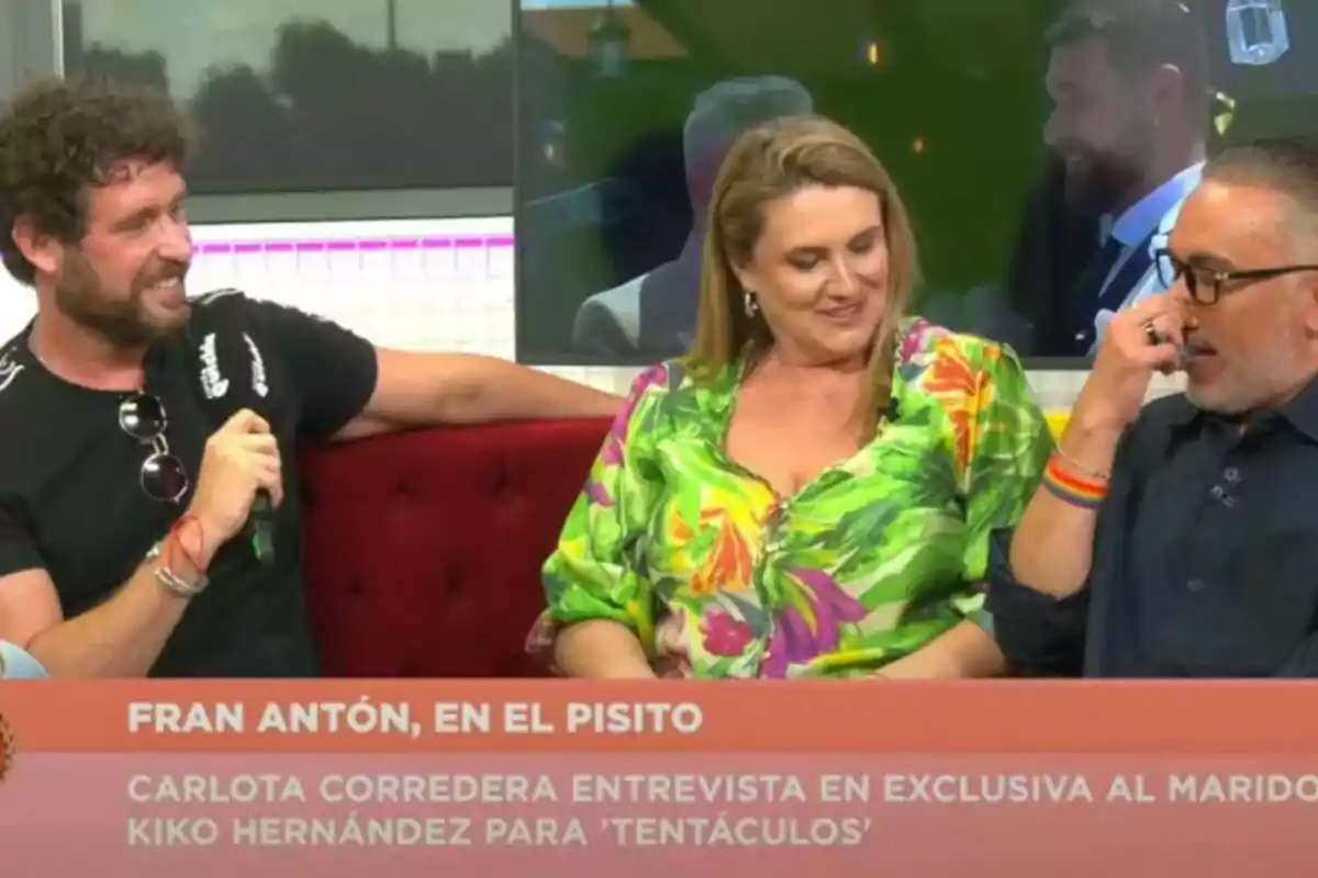 Fran Antón, Carlota Corredera i Kiko Hernández asseguts en un sofà vermell conversen i somriuen durant una entrevista a Tentáculos, amb un rètol informatiu a la part inferior de la imatge.
