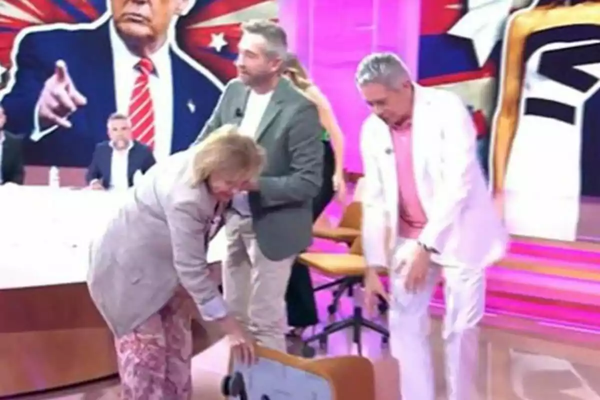 Paloma Barrientos, Frank Blanco i Boris Izaguirre en un plató de televisió a Tardear amb un fons acolorit i una imatge gran d’un home amb vestit assenyalant.