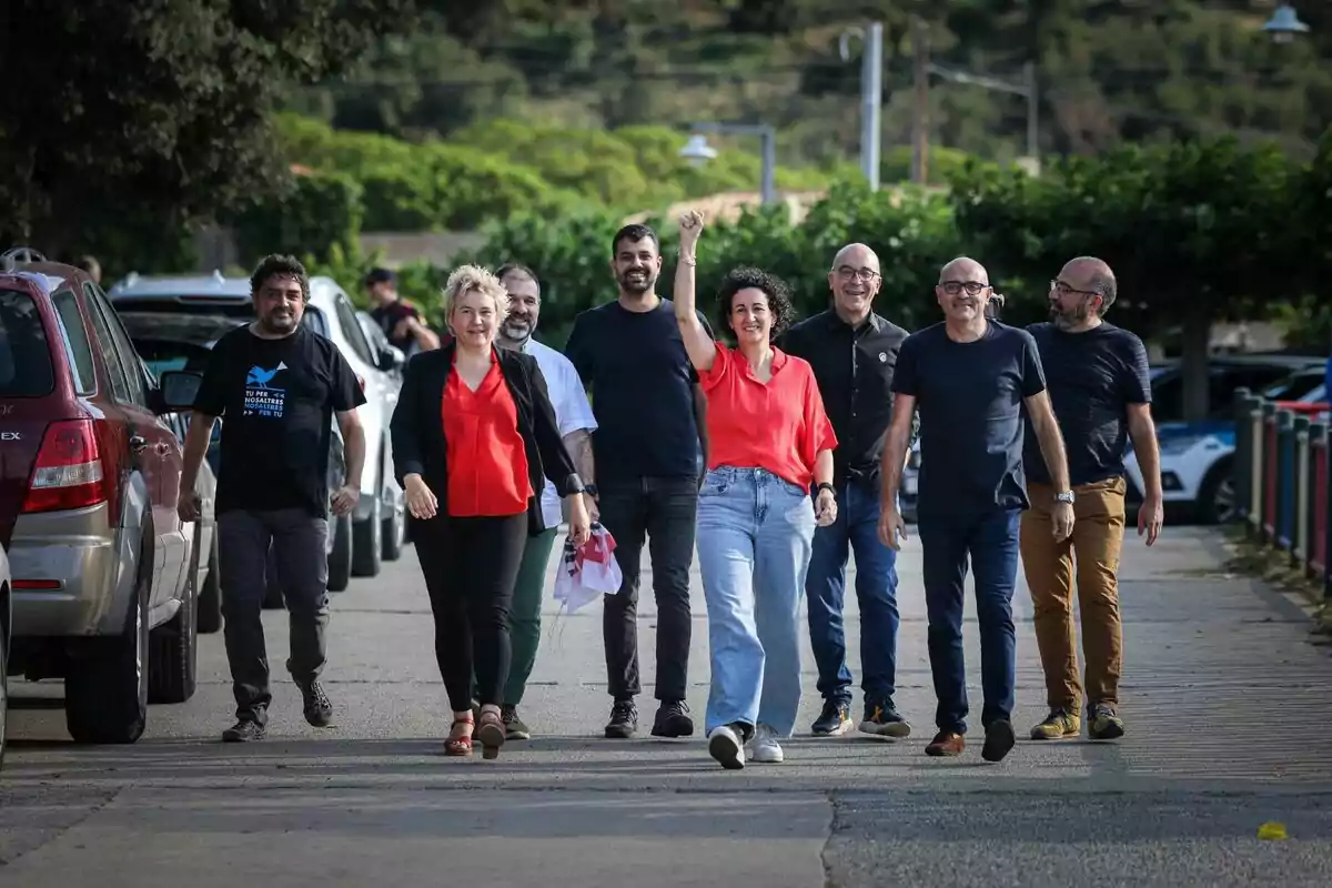 Marta Rovira, Ruben Wagensberg, Oriol Soler, Xavier Vendrell, Jesús Rodríguez i altres fugats caminant per un carrer amb arbres i cotxes estacionats als costats.