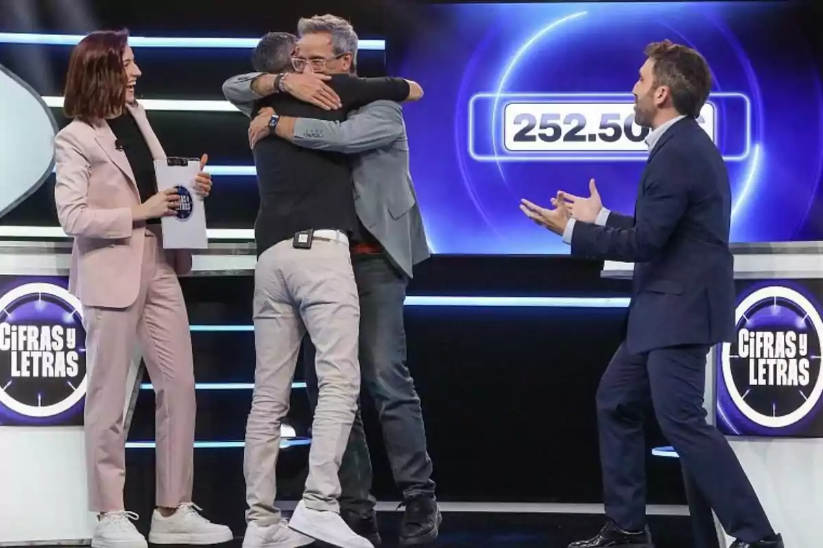 Quatre persones com Aitor Albizua celebren en un plató de televisió del programa Xifres i Lletres mentre dues d’elles s’abracen i una pantalla mostra el número 252.500.