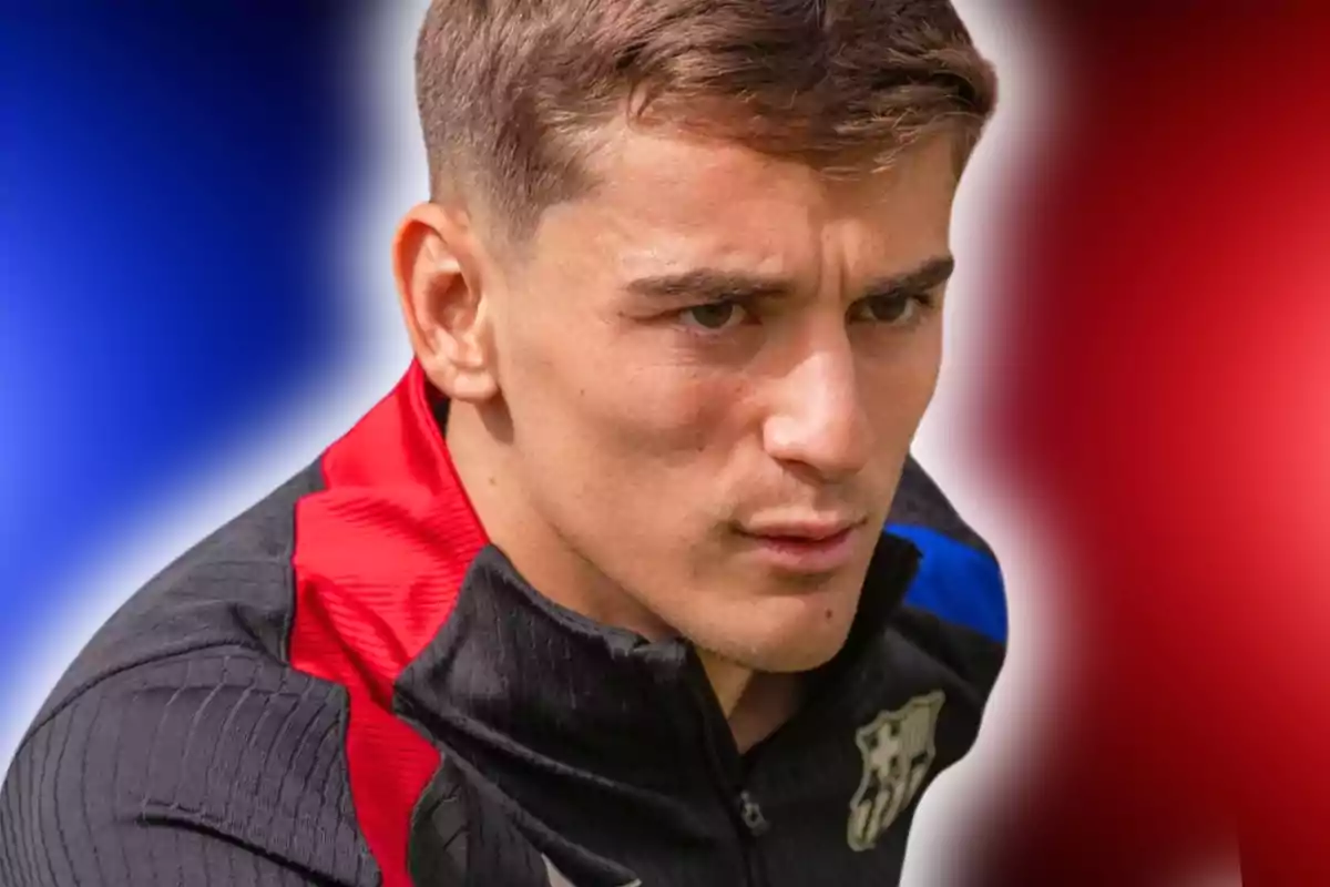 Jove amb jaqueta esportiva negra i vermella amb l’escut del FC Barcelona sobre un fons difuminat blau i vermell