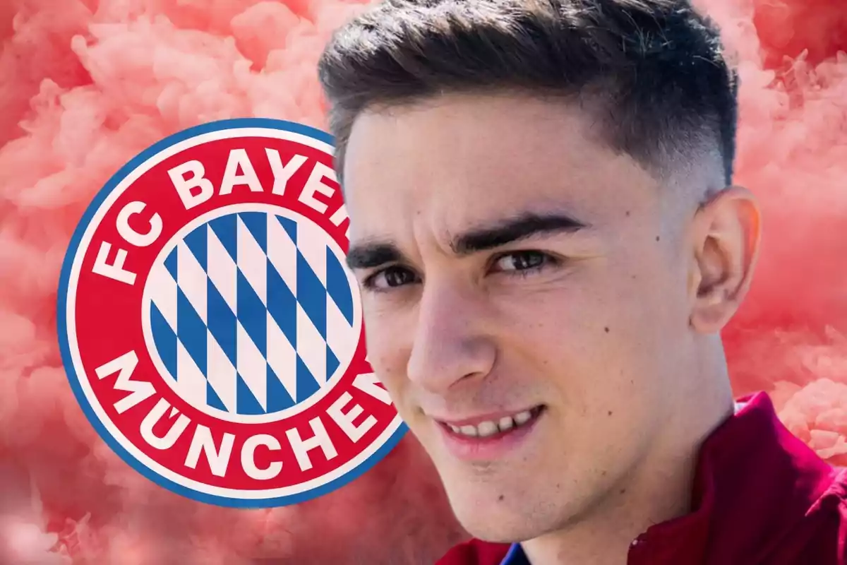 Un home jove amb una samarreta vermella davant del logotip del FC Bayern Munic i un fons de fum vermell.
