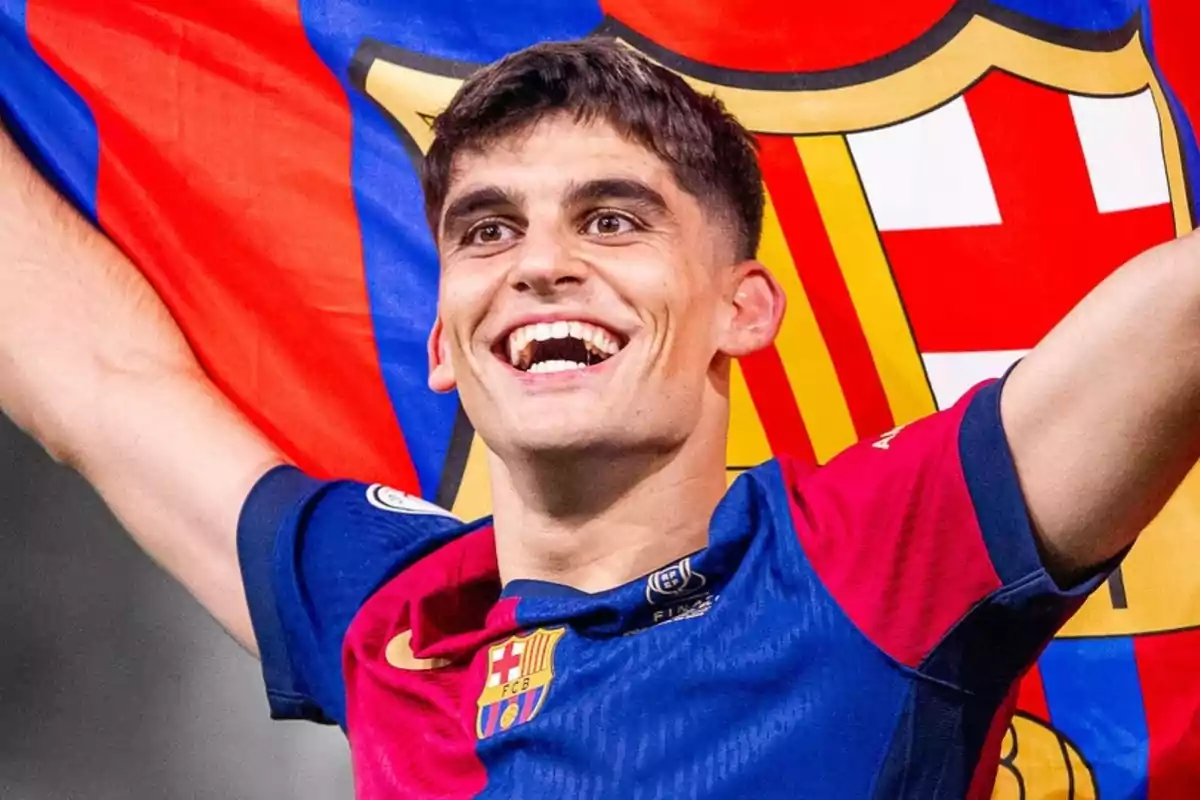 A player smiles while holding a FC Barcelona flag.